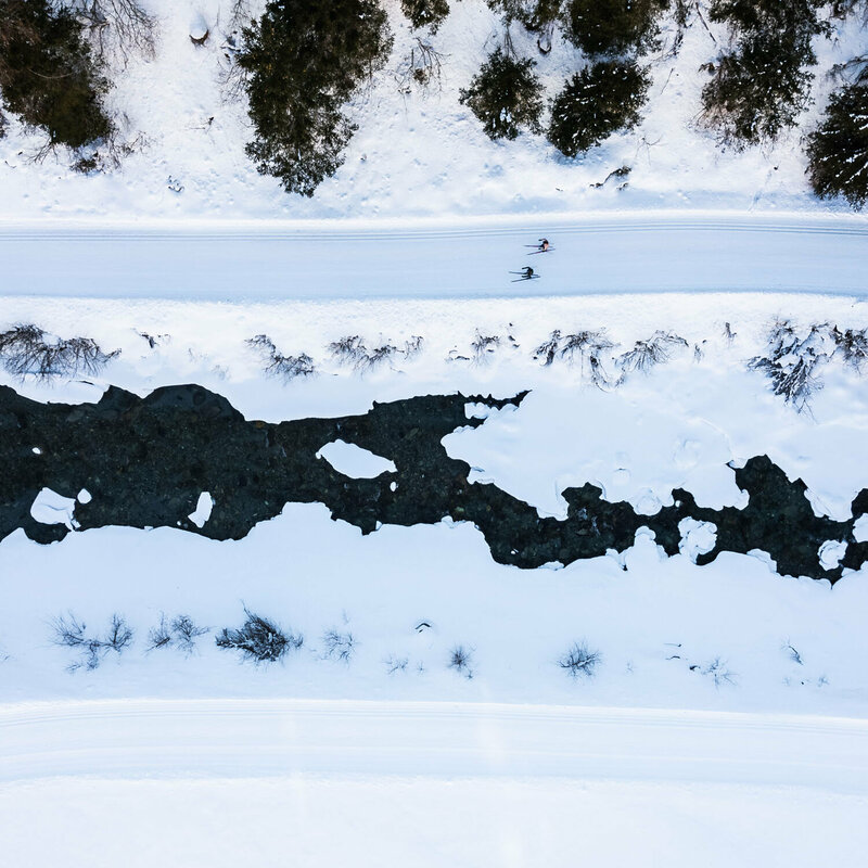 Blick auf die Langlaufloipe in Prägraten aus der Vogelperspektive mit dem daneben vorbeilaufenden Bach.