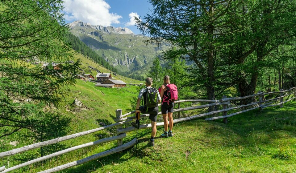 Weitwandern auf der Glocknerkrone in Osttirol, Etappe 1. Zwei Wanderer genießen den Blick auf die Äußere Steiner Alm.