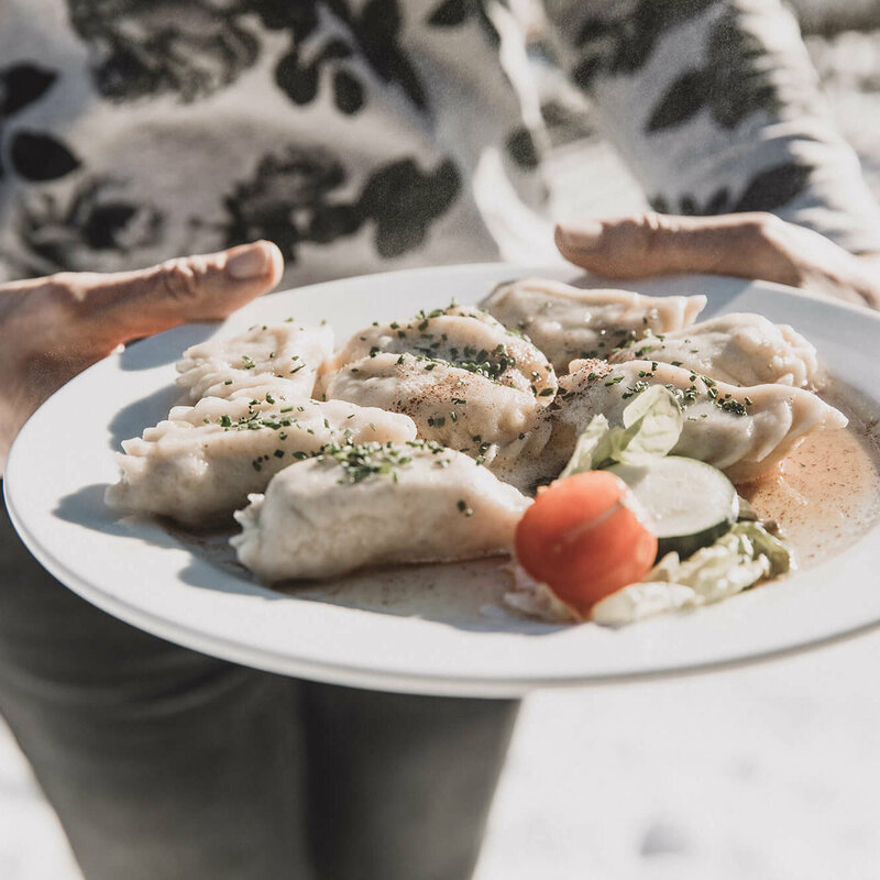 Osstiroler Schlipfkrapfen mit Schnittlauch und geschmolzener Butter und einem kleinen gemischten Salat.