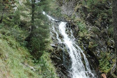 Ein Blick auf den Wasserfall in Oberhaus in St. Jakob i. D.. Das kühle Nass schlängelt sich kunstvoll durch den größten geschlossenen Zirbenwald der Ostalpen.