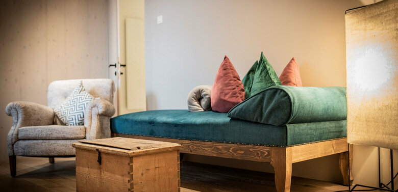 Wohnraum in der Ferienwohnung SauWohl im Kesslerstadel mit gemütlichen Sofa und Sessel.