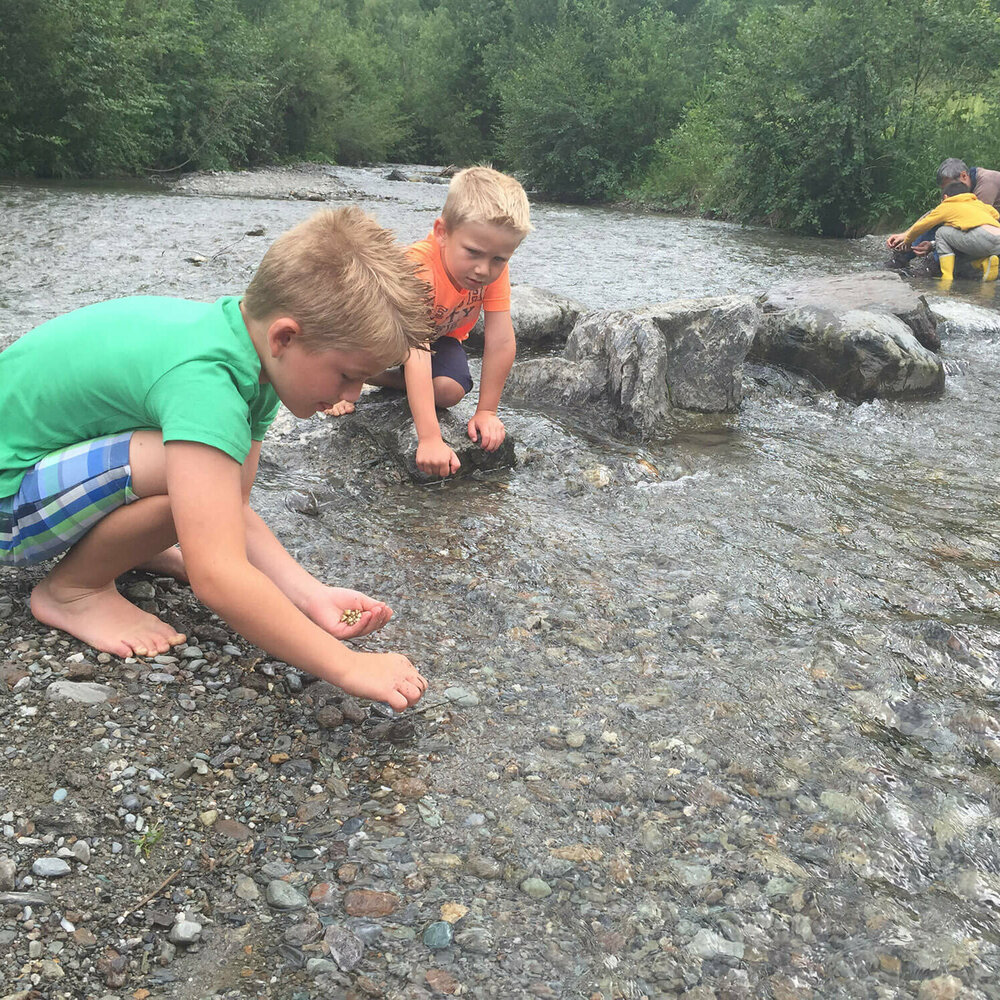 Auf dem Bild sind Kinder zu sehen, die in der Wichtelwasserwelt in Heinfels nach Gold suchen.