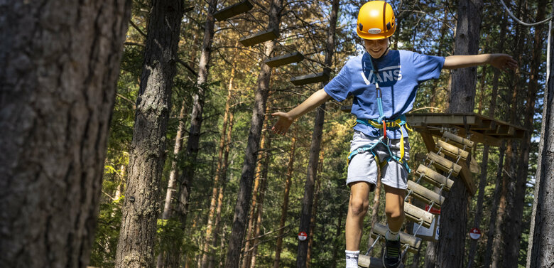 Ein junger Kletterer zeigt seine Geschicklichkeit im Kletterpark Moosalm in Lienz in Osttirol.