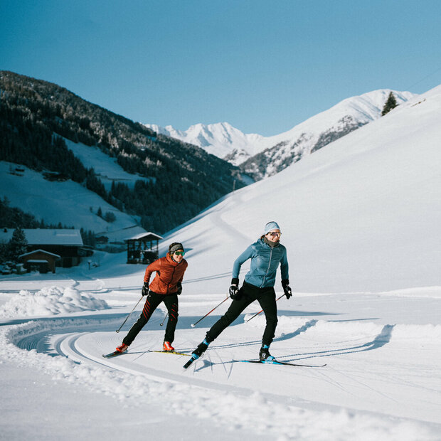 Zwei Langläufer:innen bei perfekten Loipen- und Wetterbedingungen in Innervillgraten.