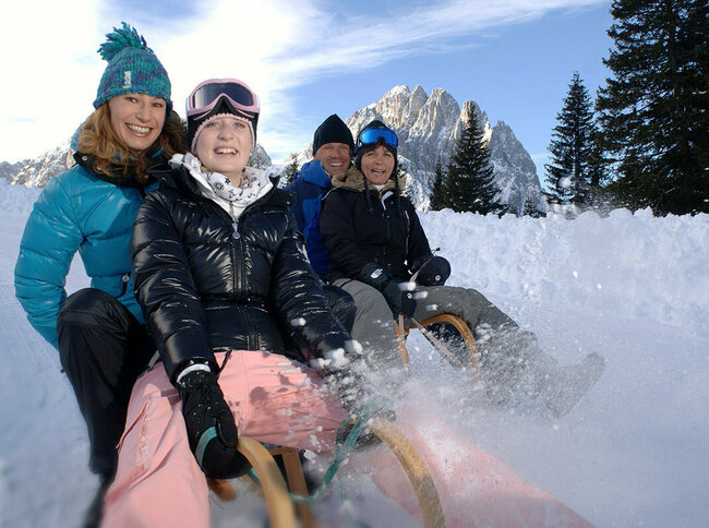 Rodelspaß zu viert bei sonnigem Wetter in Osttirol.