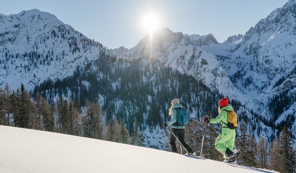 Zwei Schneeschuhwandererinnen bei strahlendem Sonnenschein in den Lienzer Dolomiten.