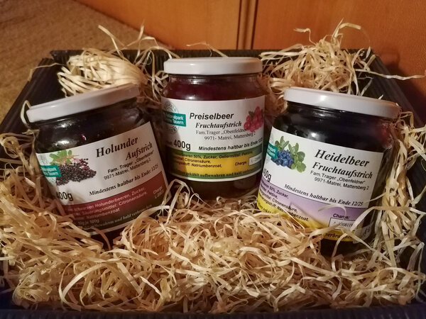 Fruchtaufstriche in einer Box mit Stroh.