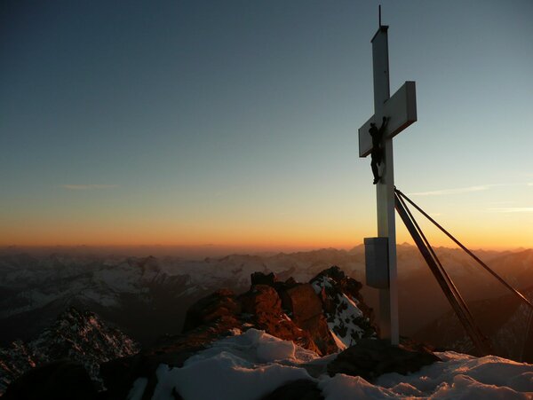 Das Gipfelkreuz des Berges Eichham bei Sonnenaufgang. 