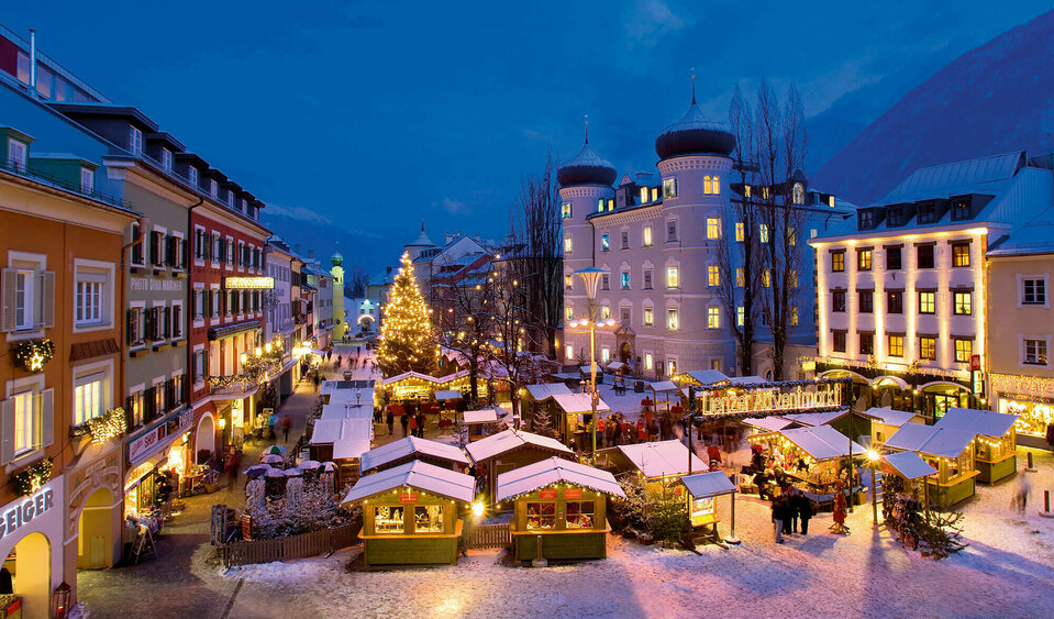 Beleuchteter Adventmarkt am Hauptplatz in Lienz in frühabendlicher Stimmung.
