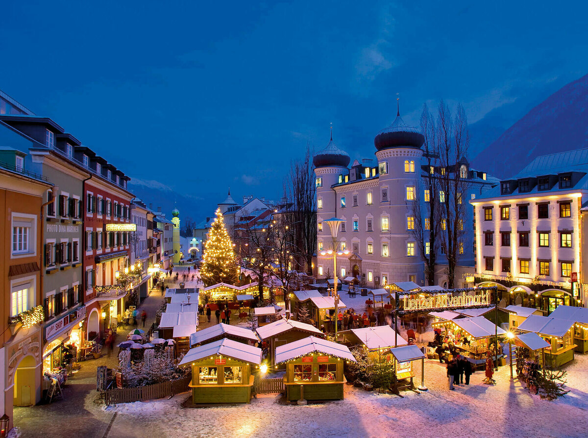 Beleuchteter Adventmarkt am Hauptplatz in Lienz in frühabendlicher Stimmung.