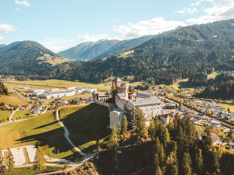 Luftaufnahme der Burg Heinfels mit der Ortschaft Heinfels im Hintergrund.