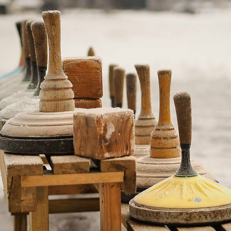 Eine hölzerne Bank voll Equipment zum Eisstockschießen.