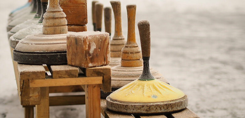Eine hölzerne Bank voll Equipment zum Eisstockschießen.