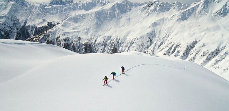 Drei Personen auf Skitour in einer unberührten Schneelandschaft in Herzassvillgraten zum Kalkstein.