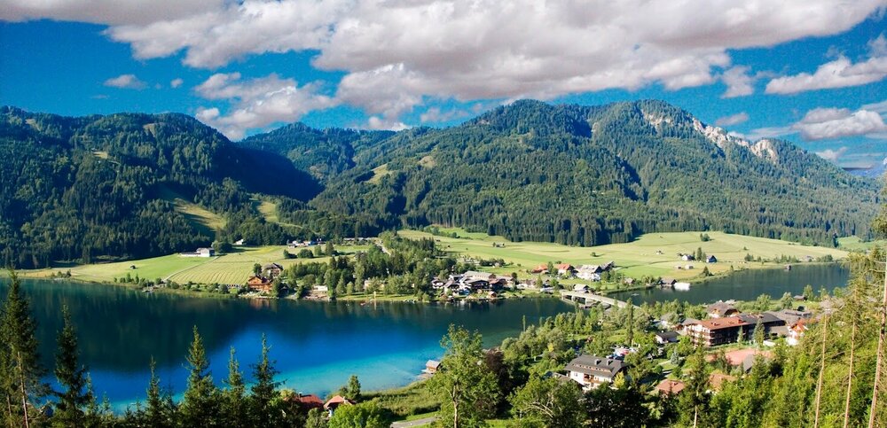 Sommeransicht von Techendorf aus der Luft mit der bekannten Brücke über den See am östlichen Ufer des Weißensees.