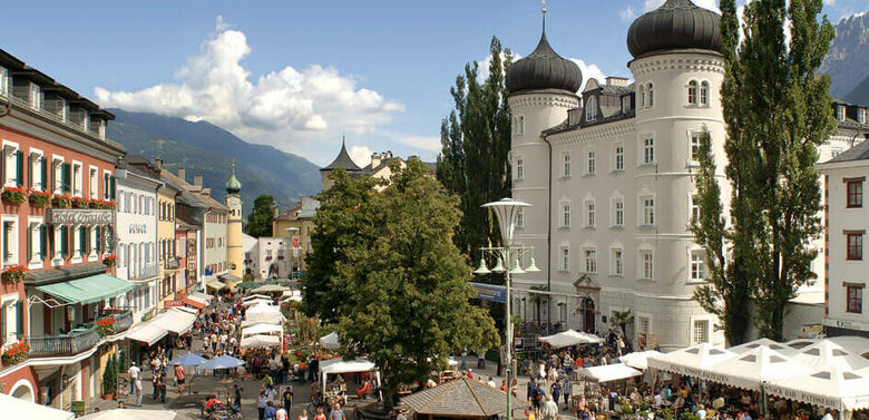 Blick von oben auf den Hauptplatz Lienz mit einigen Marktständen und Besuchern.