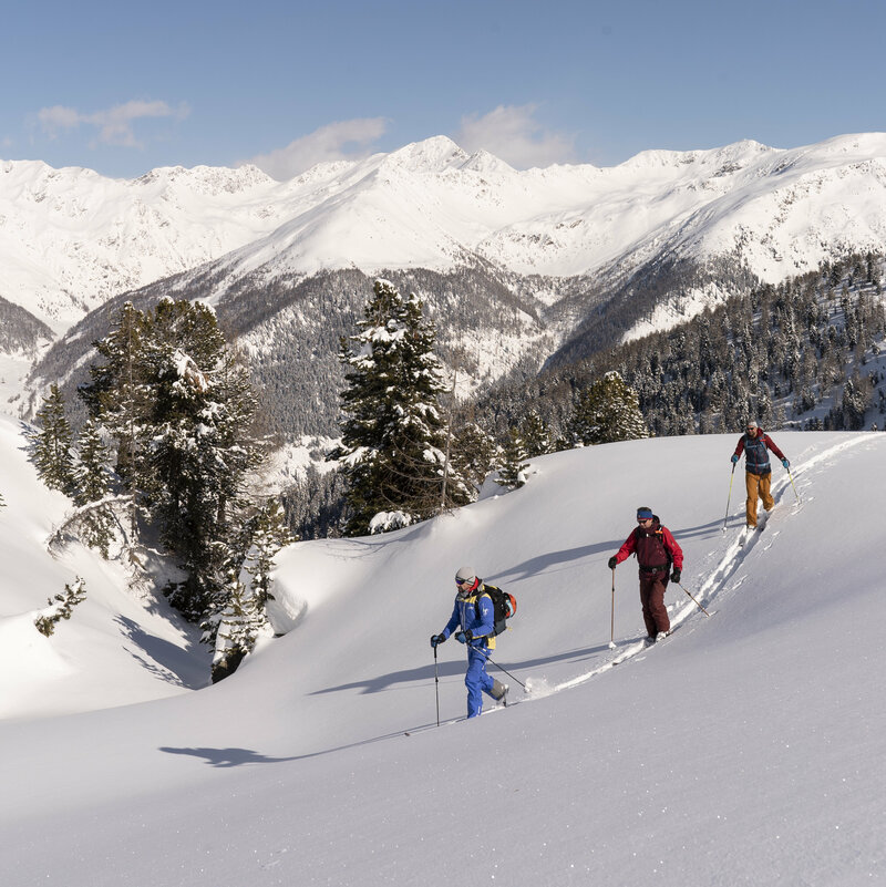 Skitourengeher:innen in Villgraten bei wolkenlosem Himmel
