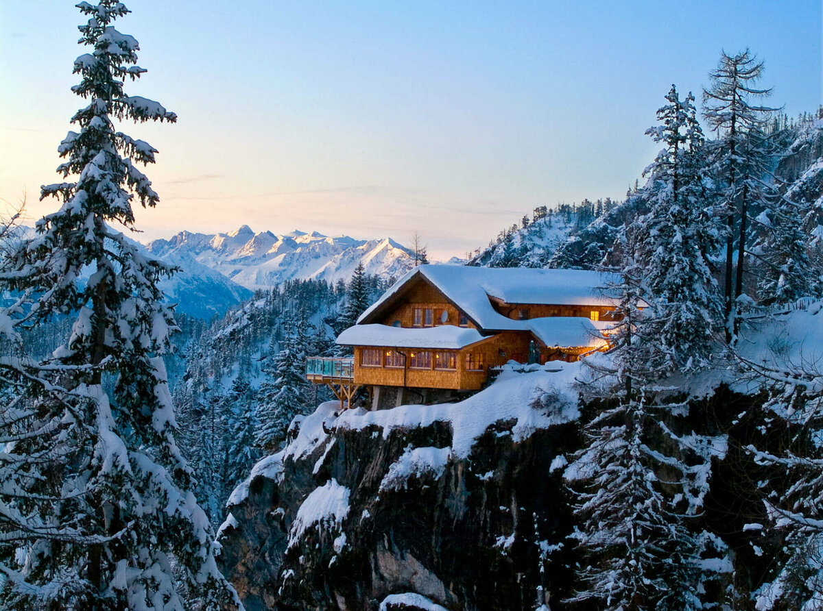 Die Dolomitenhütte auf einem Felsen in den Lienzer Dolomiten im Winter in der Dämmerung.