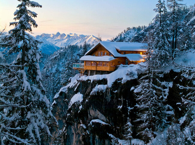Die Dolomitenhütte auf einem Felsen in den Lienzer Dolomiten im Winter in der Dämmerung.