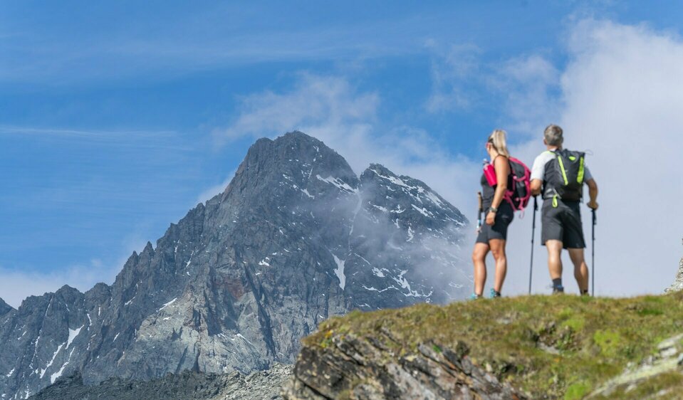 Zwei Wanderer blicken auf den Großglockner auf Etappe 3 der Glocknerkrone beim alpinen Weitwandern.
