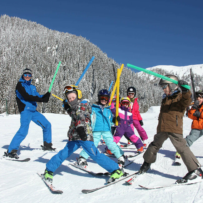 Kinderskikurs im Familienskigebiet Golzentipp Obertilliach bei frisch verschneiter Landschaft mit einem Wald im Hintergrund