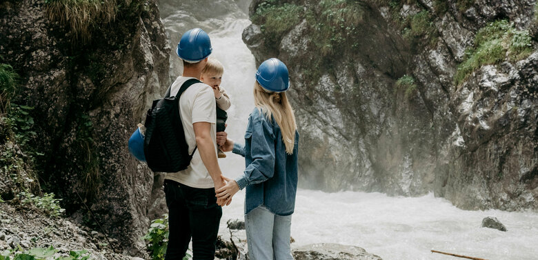 Ein Pärchen mit kleinem Kind auf dem Arm am Wasserschaupfad in der Galitzenklamm.