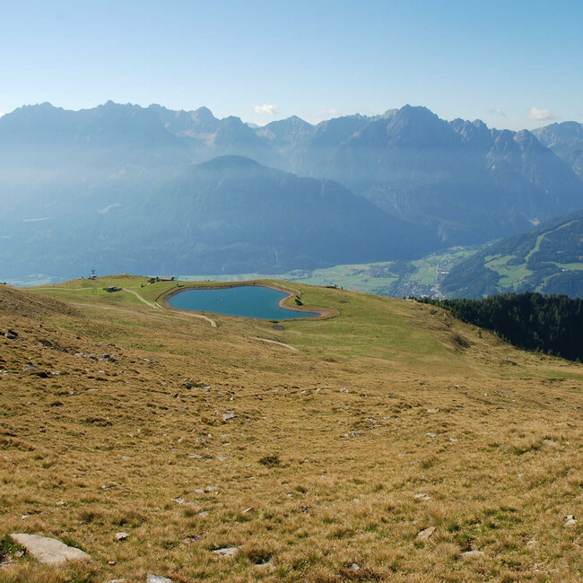 Speicherteich am Zettersfeld mit Blick auf den Lienzer Talboden und umliegende Berge der Lienzer Dolomiten