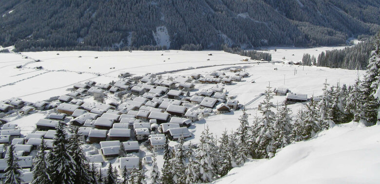 Verschneite Dorfansicht von Obertilliach aus der Luft mit Blick auf den schneebedeckten Hohen Bösring.