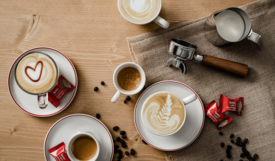 Zwei kunstvoll verzierte Cappuccinos und zwei kräftige Espressi laden zu einer genussvollen Kaffeepause ein.