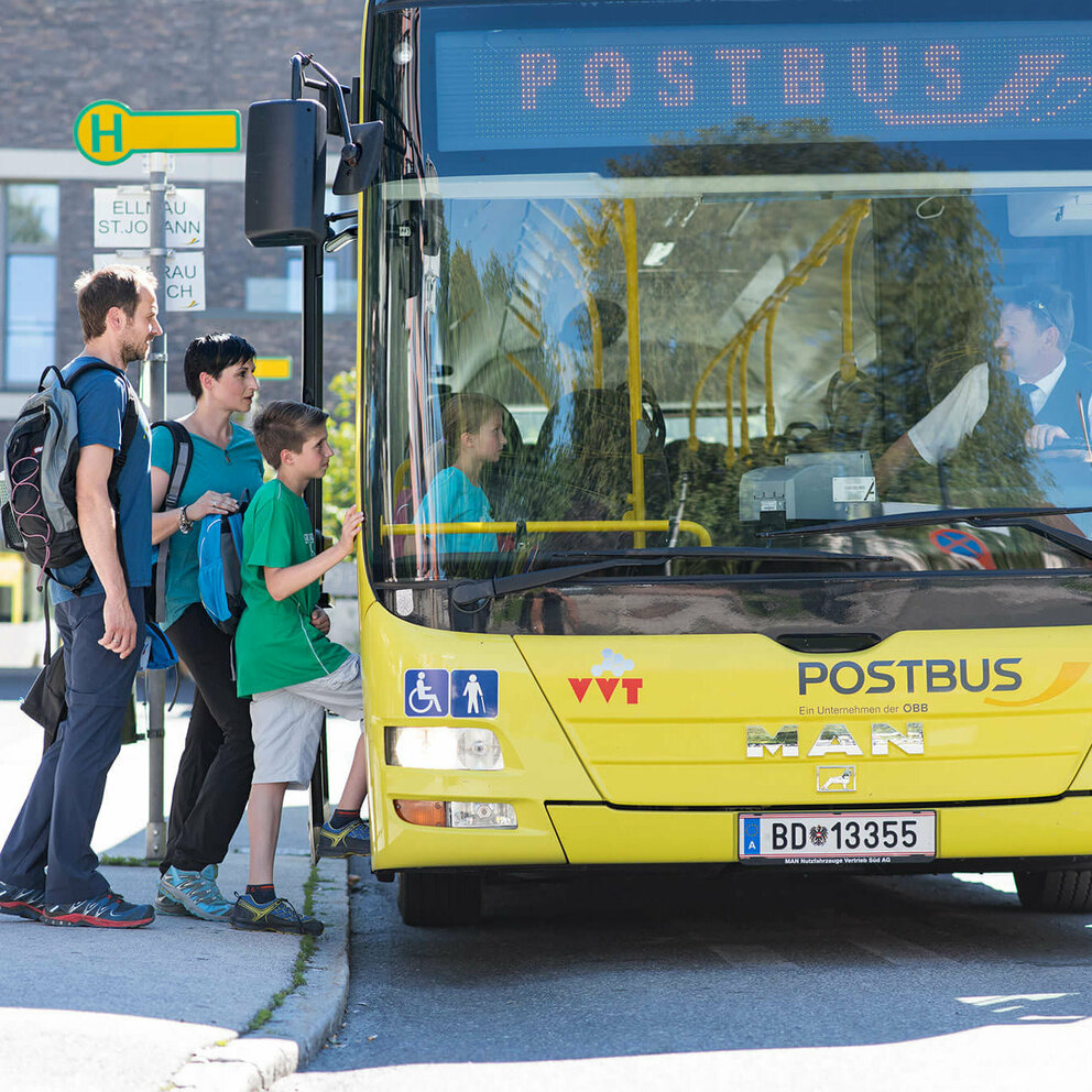 Familie steigt in gelben Postbus