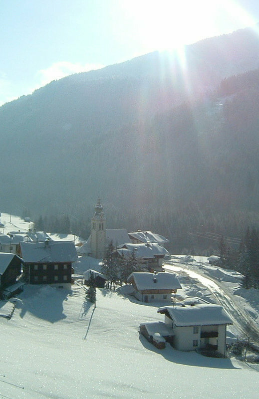 Blick auf Untertilliach mit der Kirche im Winter, nur ein paar Schritte zur Grenzlandloipe.