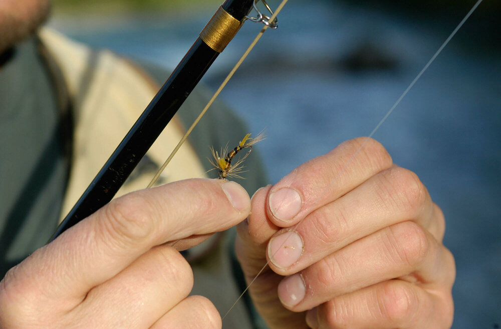 Das Bild zeigt einen Mann beim Fliegen fischen 