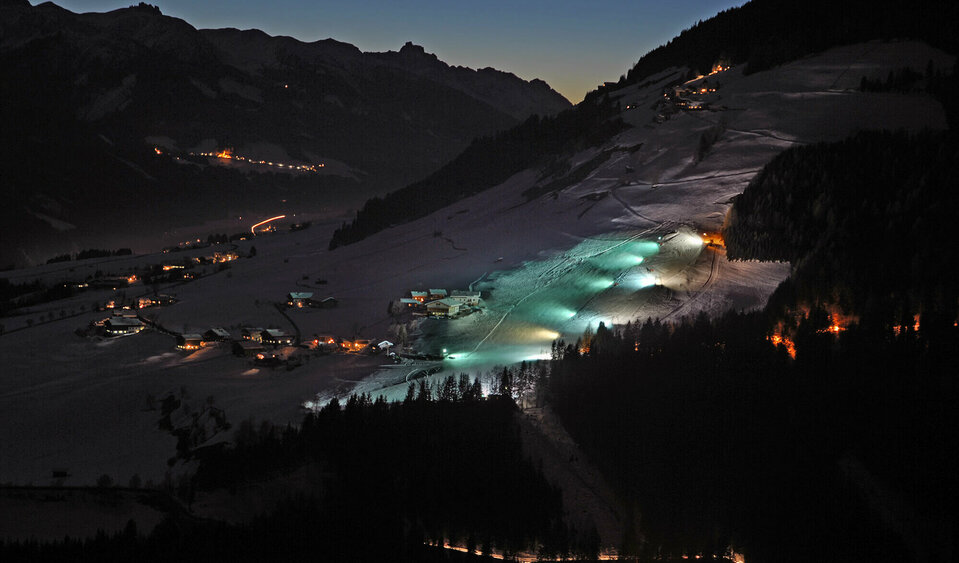 Blick auf den beleuchteten Lanalift bei Nacht in Anras.