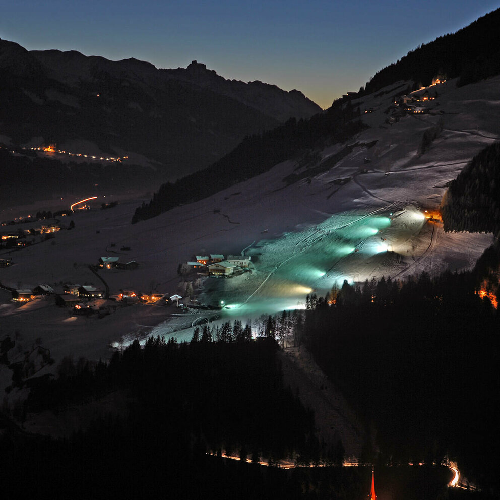 Blick auf den beleuchteten Lanalift bei Nacht in Anras.
