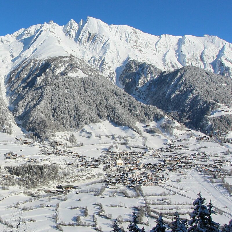 Die Gemeinde Virgen liegt tief verschneit vor imposanten Berggipfeln.