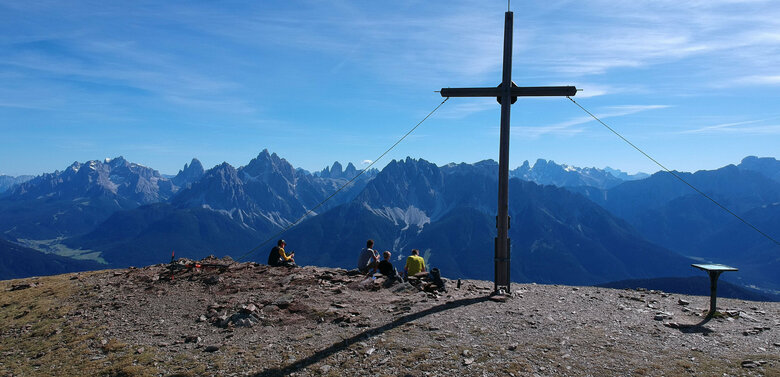 Wanderer auf bei einem Gipfelkreuz auf der Herz-Ass-Route im Villgratental