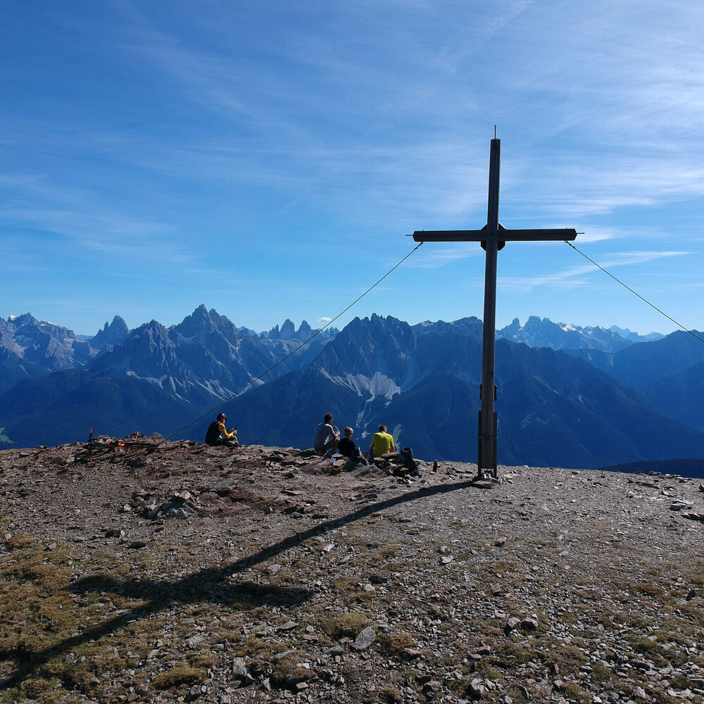 Wanderer auf bei einem Gipfelkreuz auf der Herz-Ass-Route im Villgratental