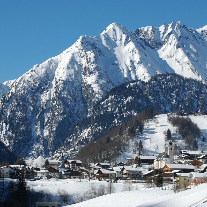 Das verschneite Praegraten im Winter mit Blickrichtung Westen und imposanter Bergkulisse.