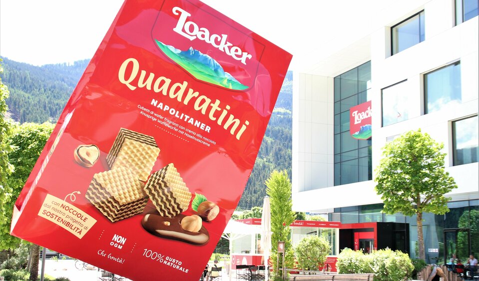 Eine übergroße, rote Waffelverpackung steht als Werbeobjekt am Parkplatz des Waffelherstellers Loacker.