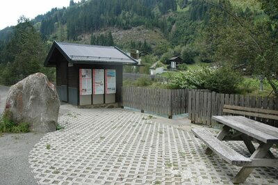 Blick auf den Pegel in Hopfgarten i. D., der direkt neben der Schwarzach gelegen ist nicht nur ein toller Aussichtspunkt sondern auch ein idealer Platz für eine Rast auf der hölzernen Bank bietet. Auf der kleinen Holzhütte die ebenfalls an diesem Platz steht, sind Informationstafeln angebracht.