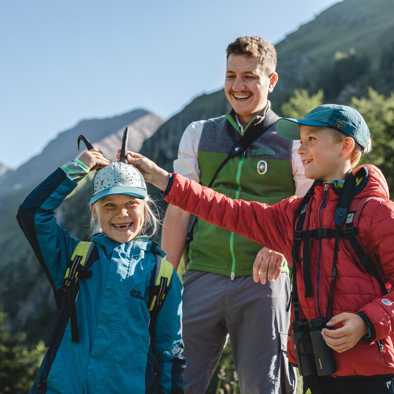 Zwei Kinder mit einem Ranger bei einer Rangetour im Nationalpark Hohe Tauern.