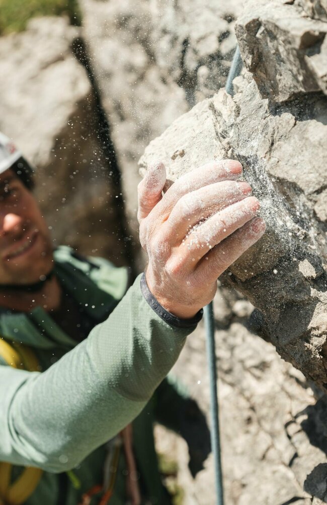 Aufnahme von der Hand eines Kletterers mit Magnesium an einem Fels.