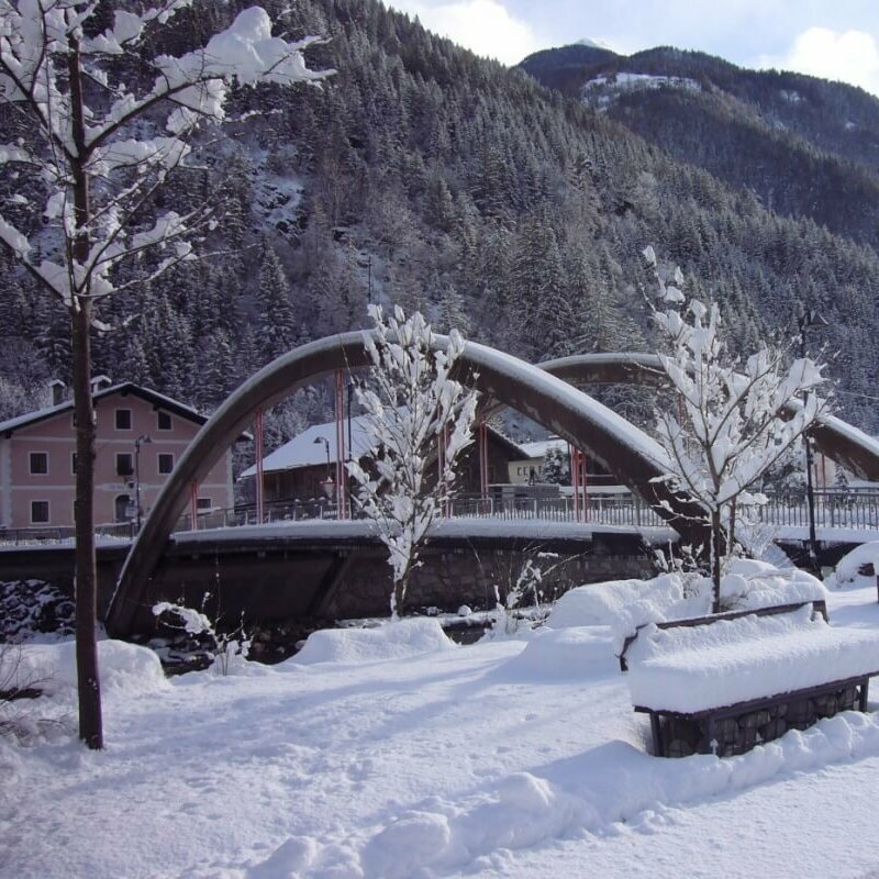 Die Brücke in St. Johann mit viel Neuschnee und einem Wald im Hintergrund.