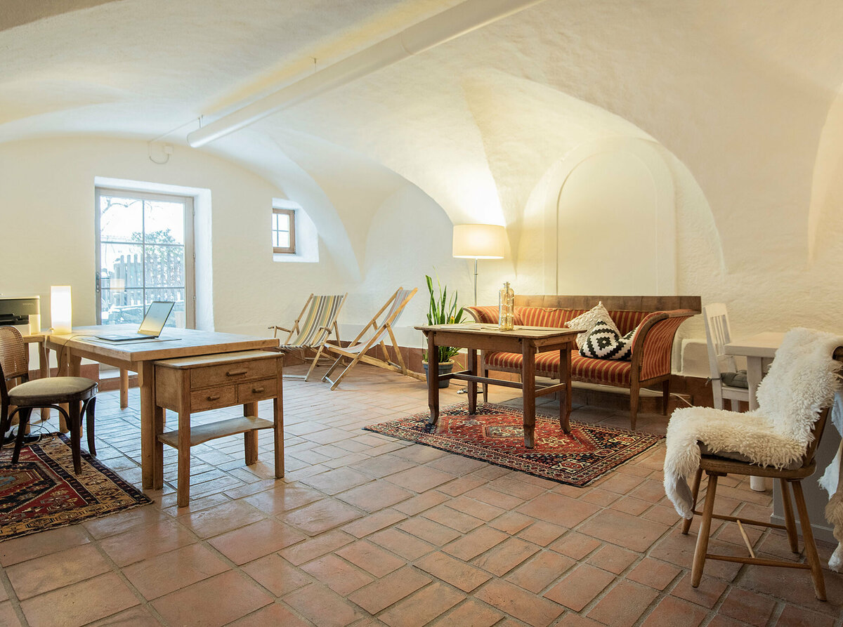 Coworking Raum im Kesslerstadel mit Arbeitstischen, Drucker und für Pausen stehen zwei Liegestühle bereit.