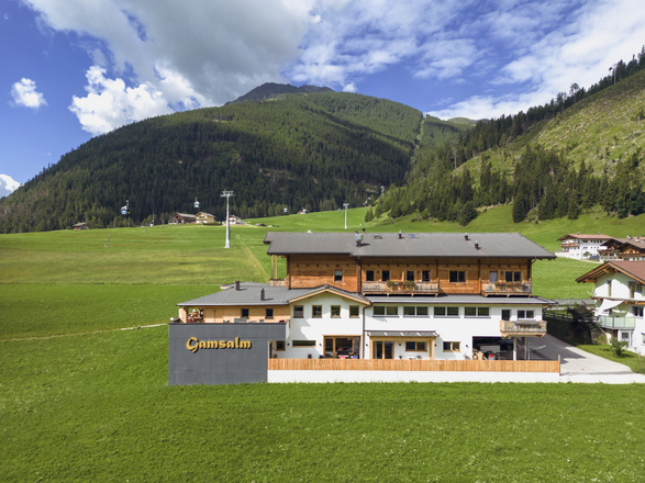 Gasthof Gamsalm umgeben von Wiesen in Kals am Großglockner. 