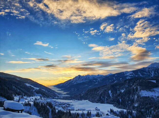 Romantische Atmosphäre beim Blick ins verschneite Lesachtal bei Sonnenaufgangsstimmung.