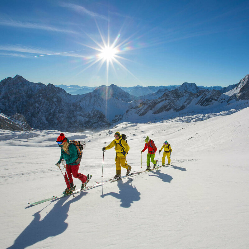 Vier Personen auf Skitour bei strahlendem Sonnenschein in der Osttiroler Bergwelt.