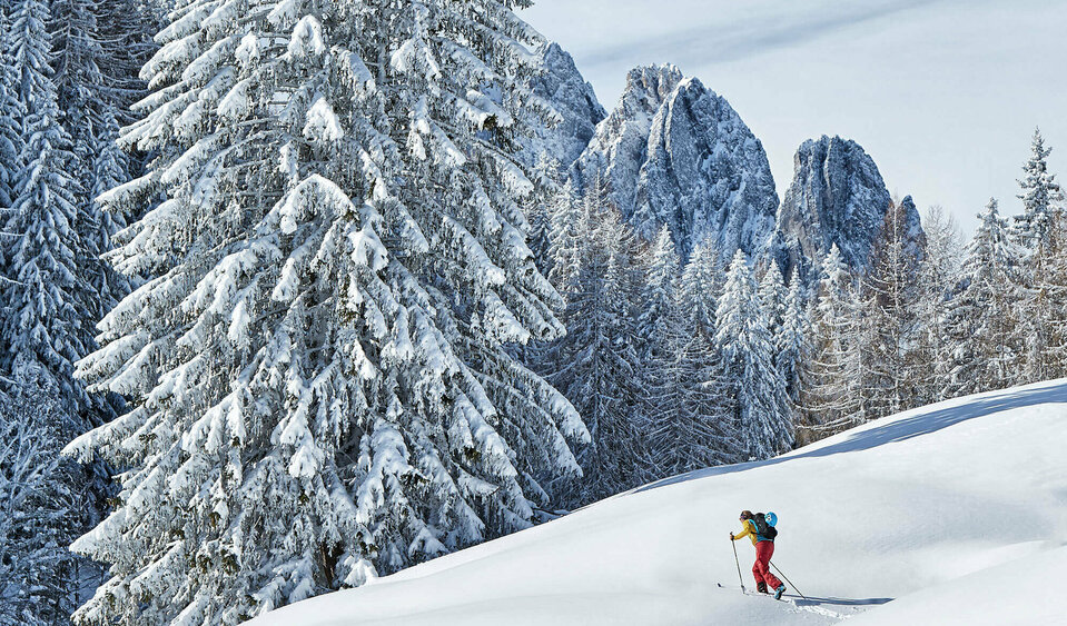 Ein Skitourengeher steigt durch tief verschneites Gelände in den Lienzer Dolomiten bei Traumbedingungen.