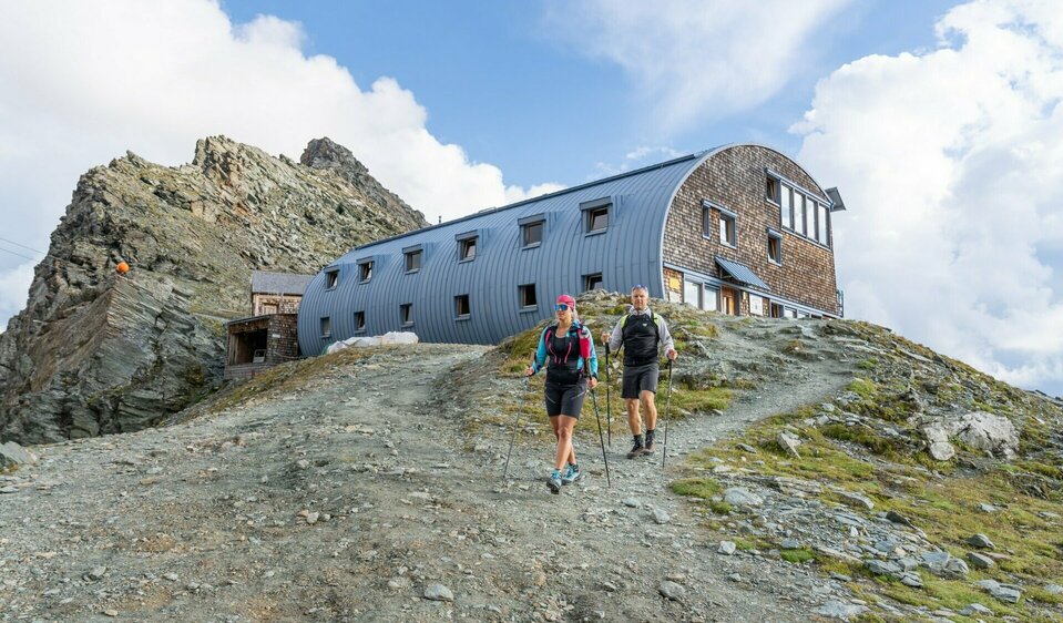 Zwei Weitwanderer vor der Stüdlhütte auf Etappe 3 der Glocknerkrone in Kals am Großglockner, Osttirol.