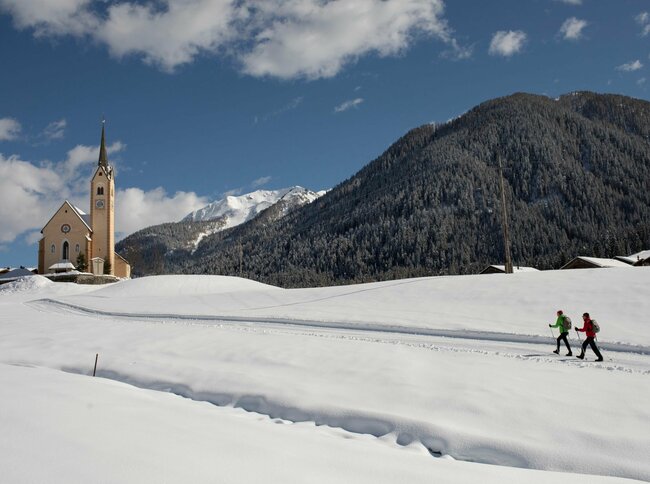 Ein Winterwanderweg in Kartitsch führt direkt bei der Pfarrkirche vorbei.